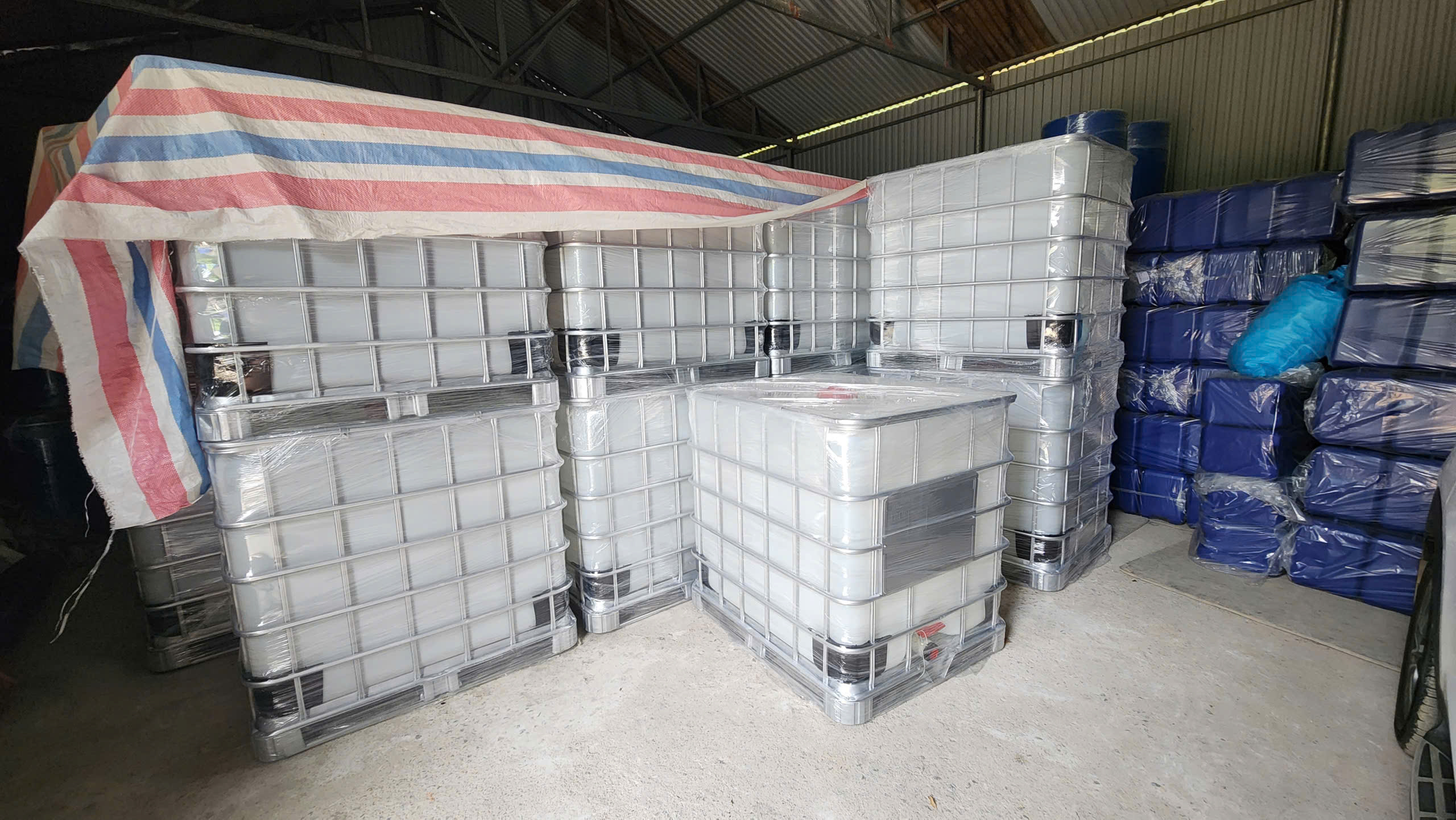 Nhà kho tôn xếp nhiều dãy bồn IBC trắng khung thép bọc màng co