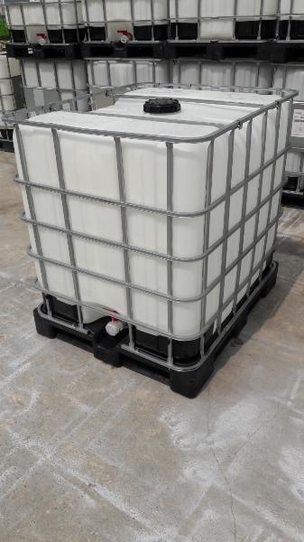 Bồn IBC trắng khung thép nắp đen trên pallet nhựa đen, sau là bồn khác