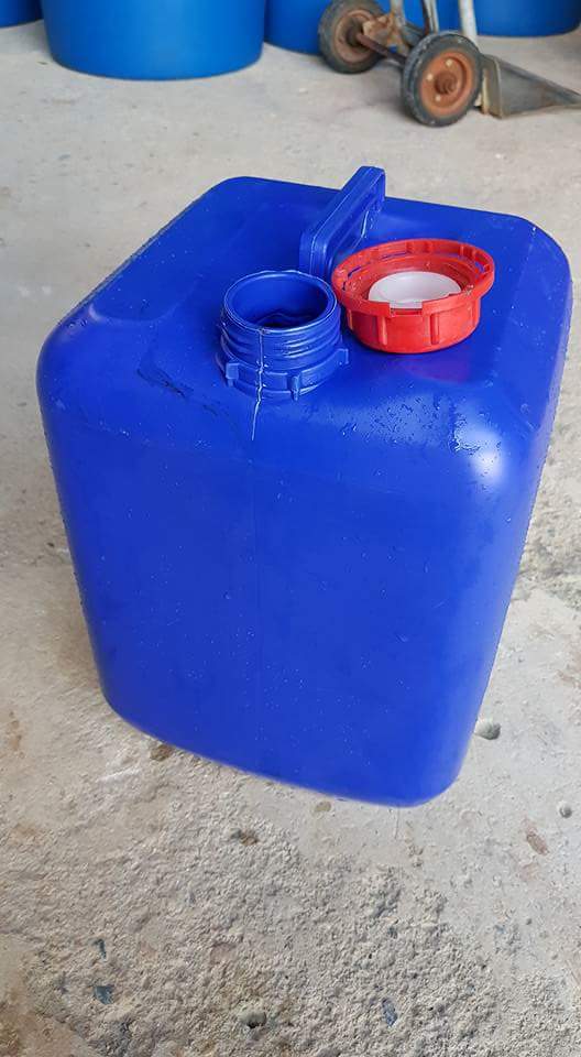 Can nhựa xanh dương thân vuông đặt trên nền xi măng, miệng rót có ren bên cạnh nắp đỏ đã tháo