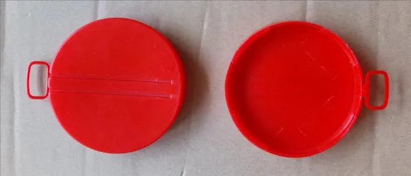 Hai nắp seal niêm phong thùng phuy bằng nhựa đỏ có vòng kéo, một chiếc lật mặt trong